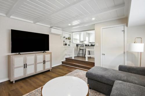 a living room with a flat screen tv on a white wall at Pet-Friendly Private Cottage In Tahoe Park in Sacramento