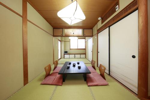 Cette chambre comprend une table et des chaises. dans l'établissement Yamadaya, à Tottori