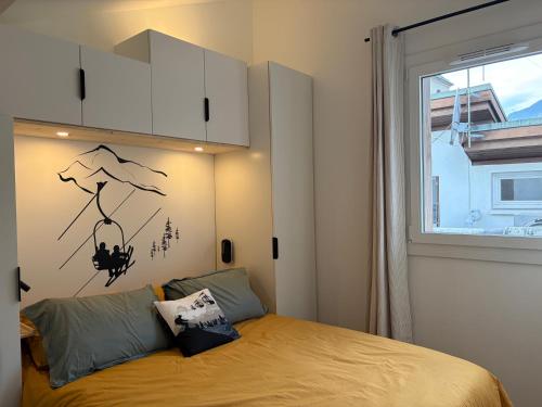 a bedroom with a bed and a window at Charmant duplex Proche station in Aime-La Plagne