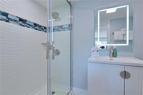 a white bathroom with a shower and a sink at The Inn on Siesta Key in Siesta Key