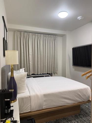 a bedroom with a white bed and a window at Sleep Inn in Brooklyn
