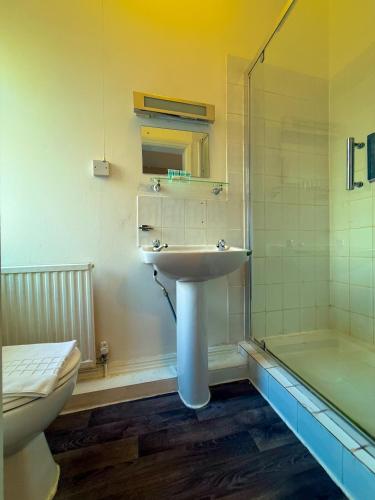 a bathroom with a sink and a toilet and a tub at Broadfield Park Hotel by Belvilla in Rochdale