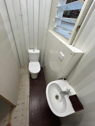 ein kleines Badezimmer mit Toilette und Waschbecken in der Unterkunft Vanuatu Kite & Surfing's Surf Lodge in Port Vila
