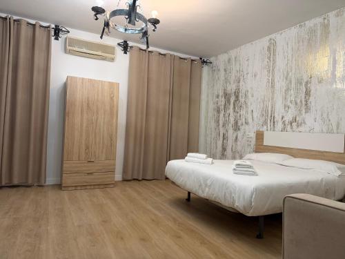 a bedroom with a bed and a chandelier at Hostal Gran Capitán in Toledo