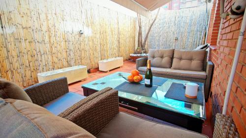 a living room with a couch and a table with a bottle of wine at Les Arts in Valencia