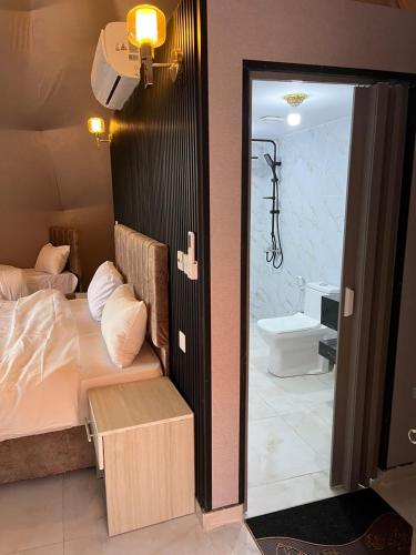 a bedroom with a bed and a bathroom with a toilet at Wadi Rum Star Haven camp in Wadi Rum