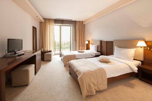 a hotel room with two beds and a television at Hotel Yesterday in Bucharest