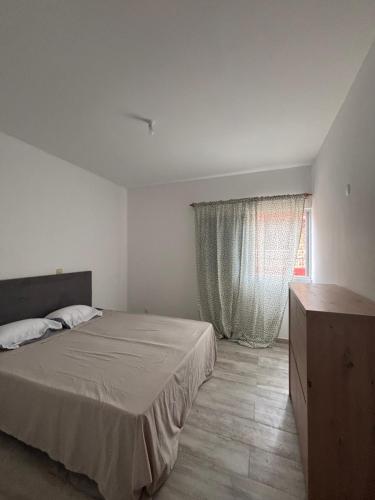 a bedroom with a large bed and a window at Caetana e Ferro in Calheta