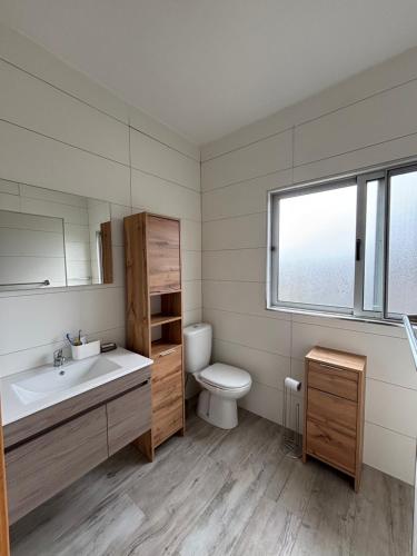 a bathroom with a sink and a toilet and a window at Caetana e Ferro in Calheta
