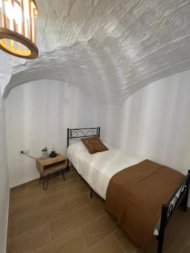 a bedroom with a bed and a table in it at Villa Marín in Aroche