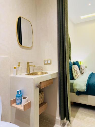 a bathroom with a sink and a mirror and a bed at RIAD El Ma in Marrakesh