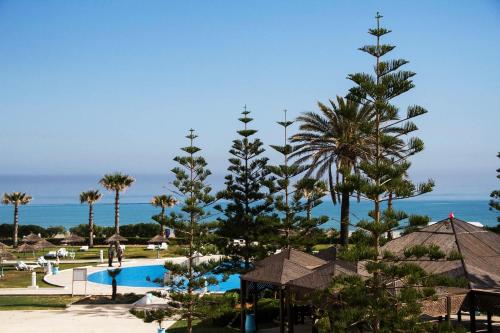 a view of a resort with a pool and palm trees at Amir Palace in Monastir