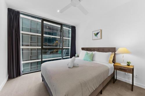 a bedroom with a bed and a large window at Brisbane One Views Level 15 2BR Apartment in Brisbane