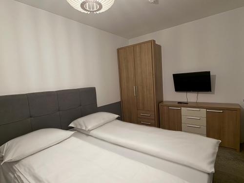 a bedroom with a bed and a cabinet and a television at Krčma Jahorina in Jahorina