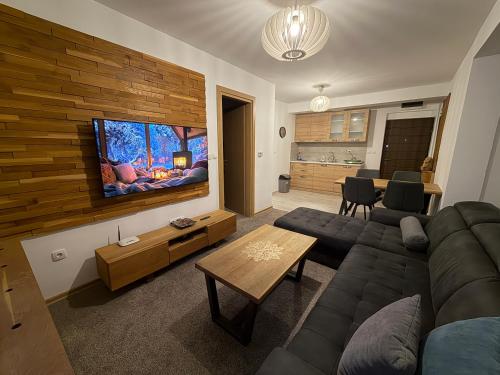 a living room with a couch and a flat screen tv at Krčma Jahorina in Jahorina