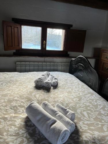 two pairs of slippers and towels on a bed at Santocasale in Rocca di Mezzo