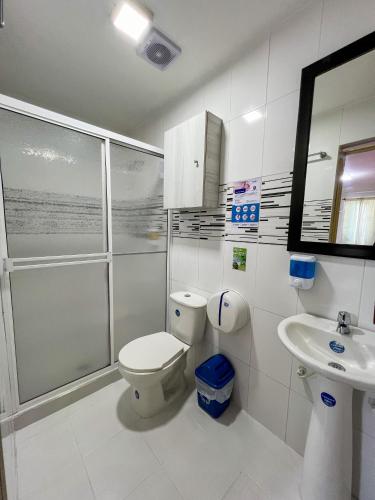 a bathroom with a shower and a toilet and a sink at Hotel Brisas De Calima in Cali