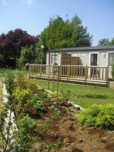 a house with a wooden fence in a yard at ZEcamping 3 étoiles - bord de Loire - proximité directe des châteaux in Sully-sur-Loire