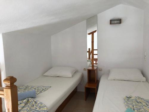 two beds in a room with white walls at Del Sol E in Skopelos Town