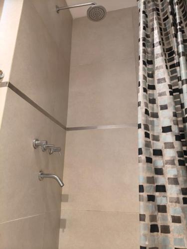 a shower with a glass door with a shower curtain at Monoambiente Premium in La Plata
