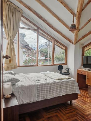 a bedroom with a bed and a large window at UMAY lodge house in Urubamba