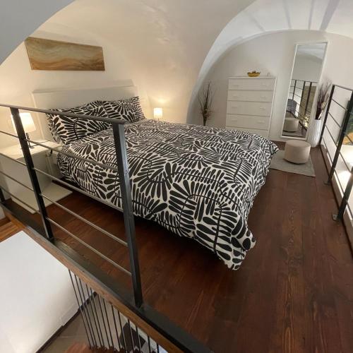 a bedroom with a bed with a black and white comforter at CasaCastellett in Modica