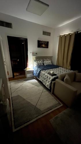 a bedroom with a bed and a couch at استديو مفروش in Abu Dhabi