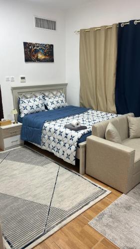 a bedroom with a bed and a couch at استديو مفروش in Abu Dhabi