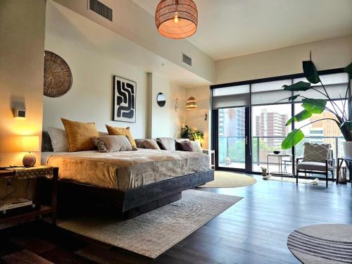 a bedroom with a large bed and a large window at Cherry Creek Rooftop Oasis in Denver