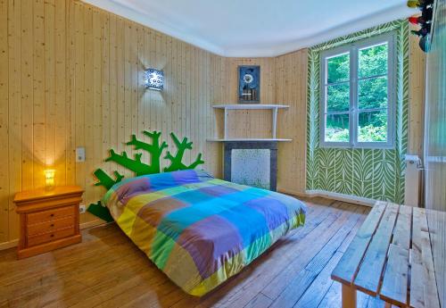 1 dormitorio con 1 cama con una manta colorida en Gitê Casa Rural El Ambigú, en Urdos