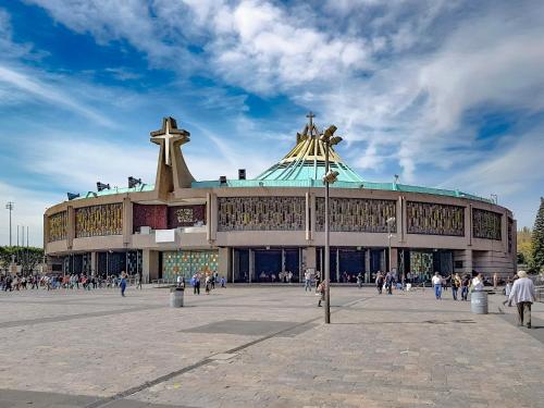 a large building with people walking in front of it at Hotel Único La Villa in Mexico City