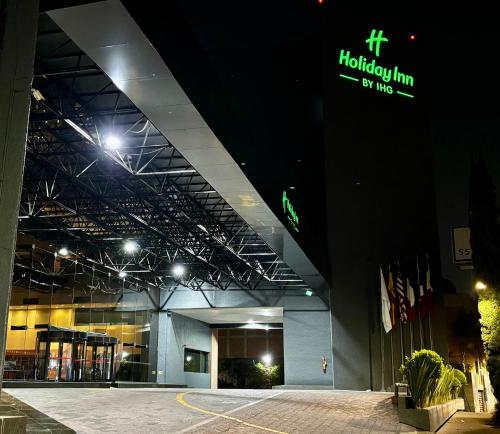 a large building with a sign on it at night at Holiday Inn Mexico Dali Airport by IHG in Mexico City