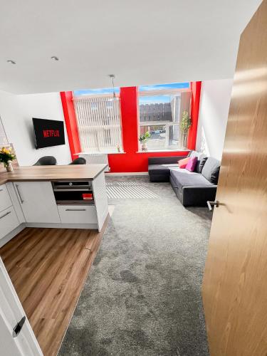 a living room with red walls and a couch at Flat 1 - Luxury Bolton City Centre Apartments in Bolton