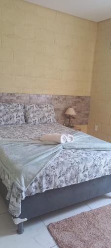 a bed in a room with a lamp next to it at Flat do Sossego 1 in Triunfo