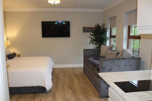 a living room with a couch and a tv on the wall at The Fairways, CastleBlayney in Castleblayney