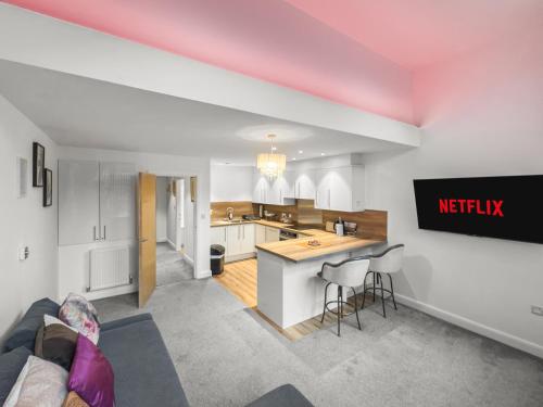 a living room with a couch and a kitchen at Flat 1 - Luxury Bolton City Centre Apartments in Bolton