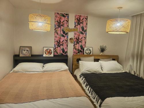 two beds sitting next to each other in a bedroom at binna stay 이태원역7분, 독채,테라스,4 Queen Beds, 무료짐보관 , 명동,홍대,서울역,명동 15분 in Seoul