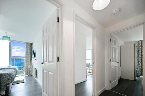 a bedroom with white walls and a large window at Hub Retreat in Milton Keynes