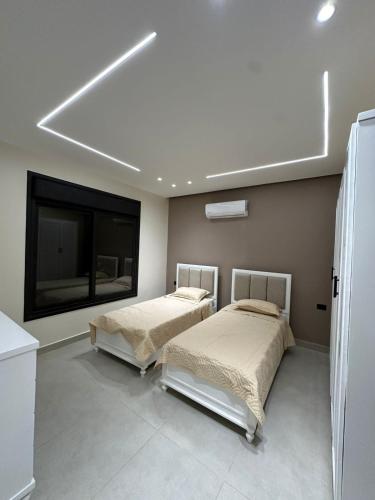 two beds in a room with a tv and a room with at شاليه الدرة Durra Chalet in Amman