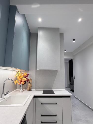 a kitchen with white cabinets and a sink at Bright 7th floor Studio-Near Center of Xanthi in Xanthi