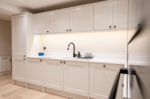 a kitchen with white cabinets and a sink at Brand New Modern 2-Bed Dog-Friendly Apartment in Broadway High Street - Sleeps 6 in Broadway