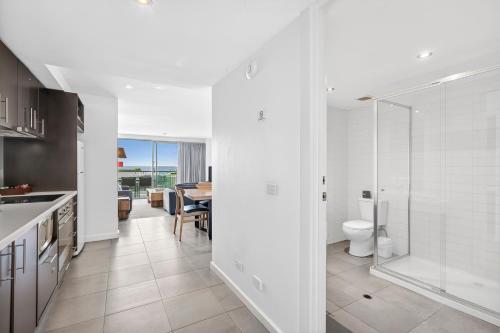 a white kitchen with a toilet and a dining room at The Dolphin Apartments in Apollo Bay