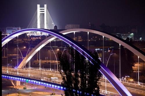 uma ponte sobre uma cidade à noite com tráfego em Hotel Yesterday em Bucareste