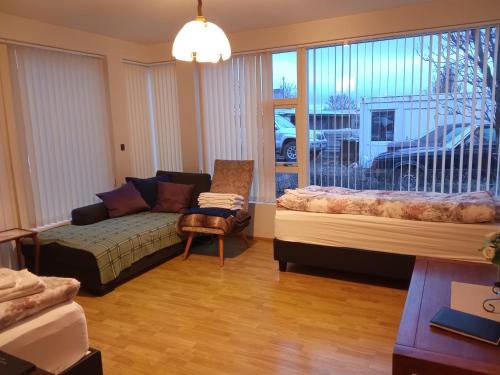 a bedroom with a bed and a couch and a window at Quiet, two bedroom apartment in Reykjavík