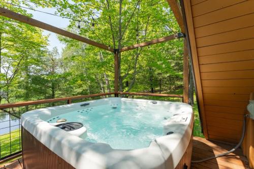 a jacuzzi tub on the deck of a house at Tamarack Lodge Tomahawk WI in Lake Tomahawk