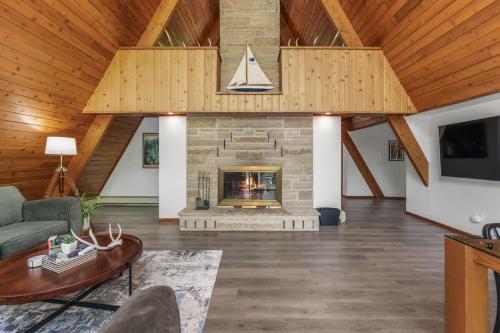 a living room with a fireplace and a wooden ceiling at Tamarack Lodge Tomahawk WI in Lake Tomahawk