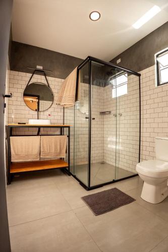 a bathroom with a glass shower and a toilet at Villa Container in the Wine Route in São Roque