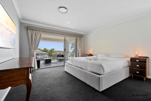 a bedroom with a bed and a desk and a window at Maison De Vacances in Banksia Beach