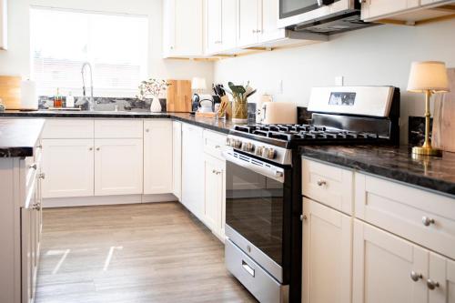 a kitchen with white cabinets and black counter tops at 5 Star Private House 5 rooms in Los Angeles