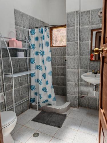 a bathroom with a shower and a toilet and a sink at UMAY lodge house in Urubamba